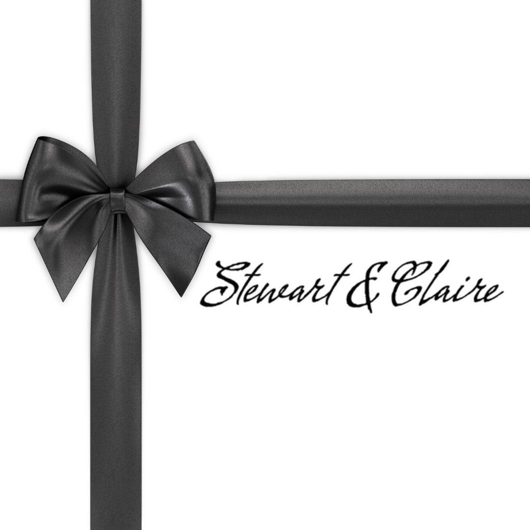 An image of a white square that looks like a gift tied with a black bow. The box says Stewart & Claire with script black letters.