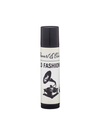 An image of a .15 ounce black plastic tube with an off-white label. The top of the label says Stewart & Claire in black script. Underneath says Old Fashioned. There is a black and white illustration of a gramophone. 