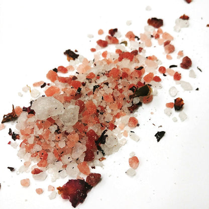 A detail image of pink and white salts blended with rose petals. 