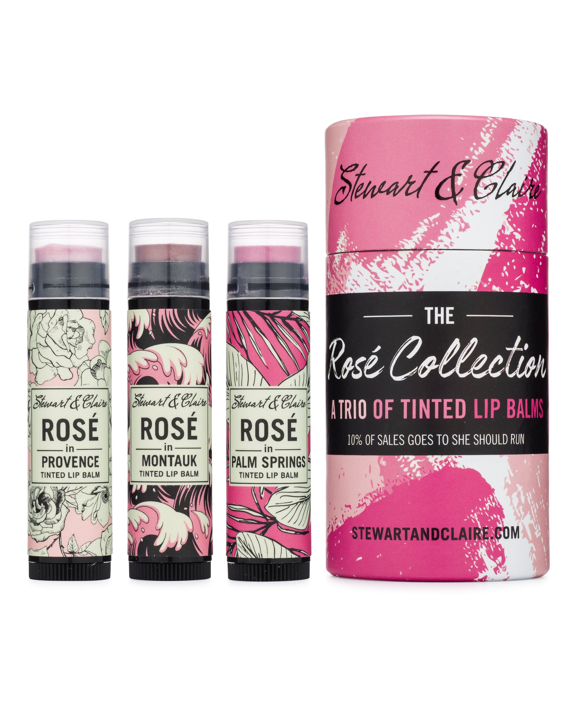 An image of three lip balms, each in black plastic tubes with clear tops. Each is a different color: From left to right: Rosé in Provence is Pale Pink, Rosé in Montauk is dusky pink, and Rosé in Palm Springs is bright pink. They are next to a larger paperboard tube with a design that looks like pink paint spatters all over it. The larger tube says The Rosé Collection: A Trio of Tinited Lip Balms